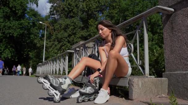 夏に公園でインラインスケートローラーを置く若い女の子 青少年レジャー屋外スポーツ活動ゲーム追求 健康的なライフスタイル — ストック動画
