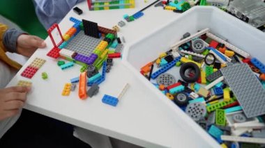 Robot programlama dersi. Çocuklar robot yapıp kodluyorlar. İnşaat blokları, dizüstü bilgisayar tableti, uzaktan kumandalı joystick kullanarak STEM eğitimi. Okul çocukları için teknolojik eğitim gelişimi