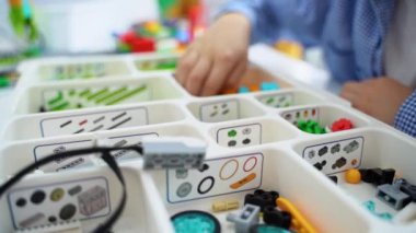 Robot programlama dersi. Çocuklar robot yapıp kodluyorlar. İnşaat blokları, dizüstü bilgisayar tableti, uzaktan kumandalı joystick kullanarak STEM eğitimi. Okul çocukları için teknolojik eğitim gelişimi