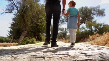 İnsanlarla seyahat et. Kafkas babası ve kızı antik orman parkında yaz mevsiminde birlikte yürürler. Çocuk mutlu bir şekilde atladı. Aile birlikte boş zaman aktiviteleri.