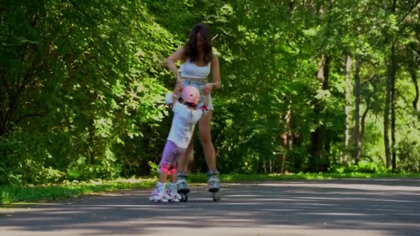 母と娘の女の子は夏の晴れた日に公園でローラーでインラインスケートを楽しむ 一緒に幸せな家族の時間 レジャースポーツ活動 — ストック動画