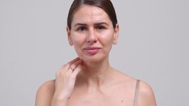 Medelålders Kvinna Berörande Ansikte Hud Vit Bakgrund Kvinnlig Årig Dam — Stockvideo