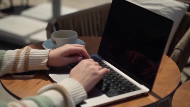 在咖啡馆外面喝咖啡时 用笔记本电脑把少女关起来 快乐的年轻女子坐在网上看学生的作文 花背景的考试研究 — 图库视频影像