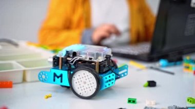 Robot programlama dersi. Çocuklar Mbot yapıp robot kodluyorlar. İnşaat blokları, dizüstü bilgisayar tableti, uzaktan kumandalı joystick kullanarak STEM eğitimi. Okul için teknolojik eğitim gelişimi