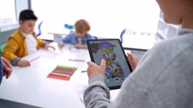İzmir Türkiye 03.01.2023 Çocuk Oyunları Artırılmış Gerçekliği. Çocuk ellerini kapat, dijital tablet oynat. Sınıf eğitiminde 3D cihaz ekranı çizerek oyna.