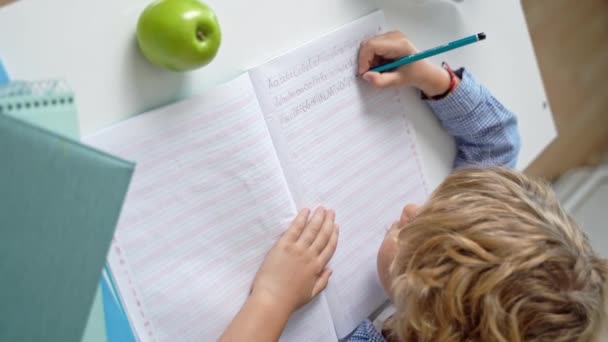 小学生男孩或女孩写信 在课桌前学习 因为白人背景回到学校 第一课 学生知识 广告的复制空间 — 图库视频影像