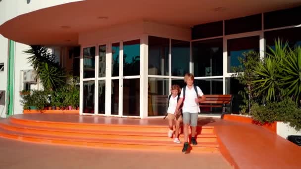 学習クラスや休憩後に両親に走るバックパックを持つ学校の生徒 学校に戻る 初等中産階級のための教育 笑顔で手を握る — ストック動画