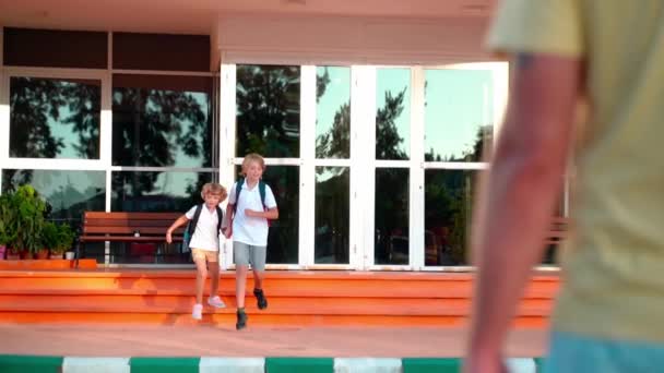 Skolelever Barn Med Ryggsäckar Som Springer Till Föräldrar Efter Lektionerna — Stockvideo
