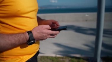 Spor faaliyetlerini yaptıktan sonra akıllı telefonu kullanarak koşan adamı kapat. Mafya uygulaması, takip cihazı, hız, kalp atışı. Sportif cep telefonu uygulamaları kullanarak idmandan sonra koşan yetişkin