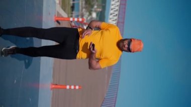 Spordan sonra koşan adam akıllı telefon kullanıyor. Dikey. Mafya uygulaması, takip cihazı, hız, kalp atışı. Sportif cep telefonu uygulamaları kullanarak idmandan sonra koşan yetişkin