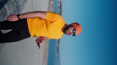 Spordan sonra koşan adam akıllı telefon kullanıyor. Dikey. Mafya uygulaması, takip cihazı, hız, kalp atışı. Sportif cep telefonu uygulamaları kullanarak idmandan sonra koşan yetişkin