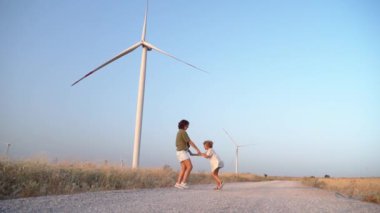 Mutlu Kadın Anne Çocuk Dans Eden Dans Eden Rüzgar Tarlasında Dönen Kız. Anne ve Kızı Birlikte Daha Çevresel, Sürdürülebilir Enerjide Temiz ve Temiz Havanın tadını çıkarıyorlar.