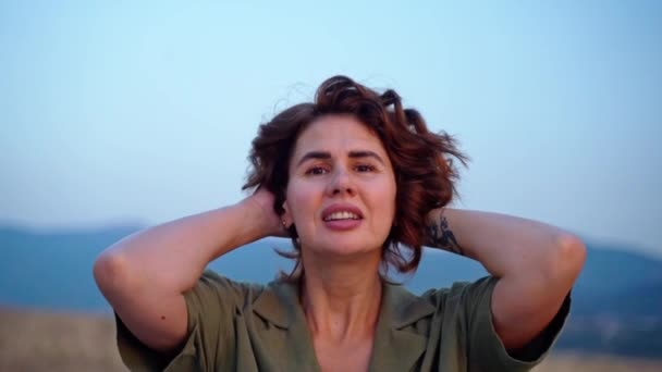 リラックスした女の子は 山の夏に日没の空の上に腕を上げる新鮮な空気を呼吸します 旅行のコンセプト 女性の精神衛生 — ストック動画