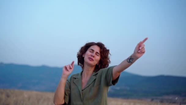 リラックスした女の子は 山の夏に日没の空の上に腕を上げる新鮮な空気を呼吸します 旅行のコンセプト 女性の精神衛生 — ストック動画