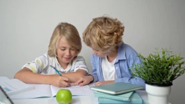 İlkokul ortaokul öğrencisi kız kardeşler masa başında okuyorlar, kitap yazıyorlar ve ev ödevlerinde tablet yazıyorlar bilgi ediniyorlar okula dönüyorlar..