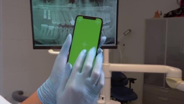 Κοντινό Πλάνο Χέρια Οδοντίατρος Αποστειρωμένο Γάντι Κρατήσει Πράσινο Κινητό Τηλέφωνο — Αρχείο Βίντεο