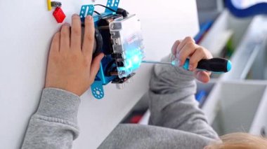 Robot programlama dersi. Çocuk, Mbot tornavida ve kod robotu yapıyor. İnşaat blokları, dizüstü bilgisayar tableti, uzaktan kumandalı joystick kullanarak STEM eğitimi. Teknoloji eğitimsel gelişimi