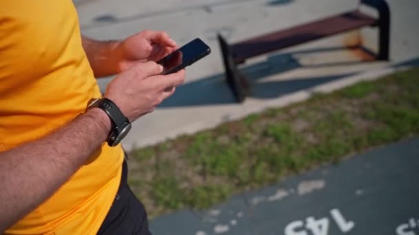 跑完体育活动后 用智能手机把慢跑者关起来 Mob应用程序 跟踪器 使用手机运动应用程序锻炼后跑步的成年人 — 图库视频影像
