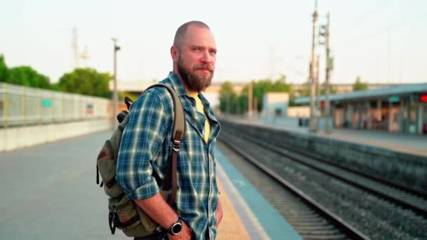 鉄道プラットフォームの地下鉄を待っているバックパックを持つ男 公共交通機関について 都市生活の市民は 地下鉄を利用して朝に働く — ストック動画