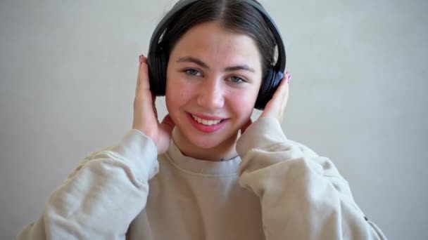 Kulaklıklı Genç Bir Kız Kameraya Bakıp Gülümsüyor Müzik Dinliyor Dans — Stok video