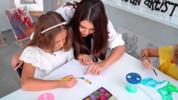 艺术学校的教师帮助孩子们学习绘画水彩画 一组小学生学习绘画和色彩 Hobby — 图库视频影像