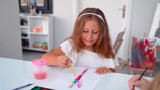 在艺术课演播室里用水彩画用画笔水彩画 小学生小组学习如何在老师的帮助下绘画和配色 — 图库视频影像