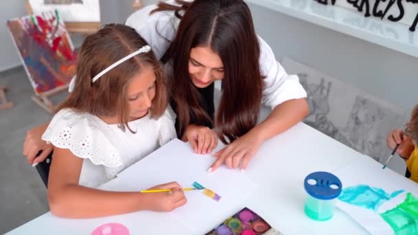 Docent Kunstschool Kinderen Helpen Kunstklas Met Aquarelverf Schilderen Groep Basisschoolkinderen — Stockvideo