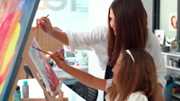 스쿨의 그림으로 클래스에서 아이들을 여성은 아이에게 아크릴 페인트를 만들고 사용하도록 — 비디오