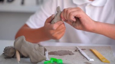 Sanat okulundaki genç çocuk, Sanat sınıfındaki Clay Sculpt. Ortaokul çocuğu öğretmenin yardımıyla yaratmayı öğreniyor.