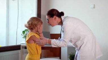Çocuk aşısı çocuk hastanesi kliniğinde. Şırıngayla doktor enjeksiyonu. Hemşire sakin çocuk sağlıklı yaşam tarzı ve bakım kavramından korkuyor.