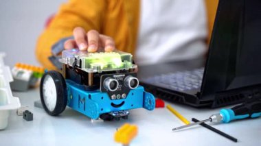 Robot programlama dersi. Çocuklar Mbot yapıp robot kodluyorlar. İnşaat blokları, dizüstü bilgisayar tableti, uzaktan kumandalı joystick kullanarak STEM eğitimi. Okul için teknolojik eğitim gelişimi
