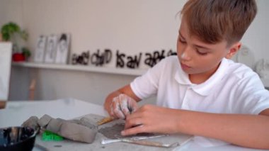 Sanat okulundaki genç çocuk. Sanat sınıfındaki Clay Sculpt. Ortaokul çocuğu nasıl yaratılacağını öğreniyor