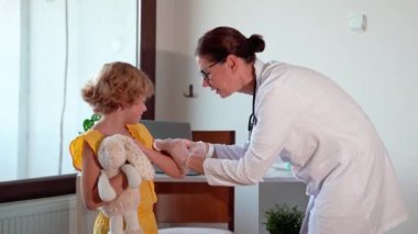 Çocuk aşısı çocuk hastanesi kliniğinde. Şırıngayla doktor enjeksiyonu. Çocuğun sağlıklı yaşam tarzı ve bakımı hakkında olumlu düşünceler.