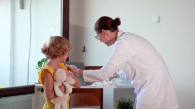 Çocuk aşısı çocuk hastanesi kliniğinde. Şırıngayla doktor enjeksiyonu. Çocuğun sağlıklı yaşam tarzı ve bakımı hakkında olumlu düşünceler.