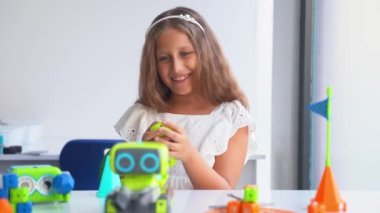 Teknolojik eğitim sınıfında oyuncak araba kontrol paneliyle oynayan bir çocuk. Okullu çocuklar teknolojinin ilk adımlarını keşfediyorlar. Eğitim geliştirme kavramı