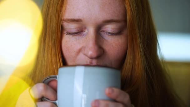 Zbliżenie Rudej Kobiety Przytulnej Koszulce Pijącej Ciepłą Herbatę Uśmiechającej Się — Wideo stockowe
