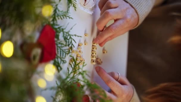 在圣诞花园灯和松树枝头挂满了字母的木块的陪伴下 女性的亲密双手欢欢喜喜地度过新年 装潢师为网上购物提供装饰 垂直方向 — 图库视频影像