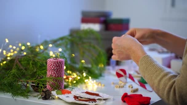 Close Handen Naaldvrouw Decorateur Maken Kerstversiering Slinger Nieuwjaar Speelgoed Marionet — Stockvideo