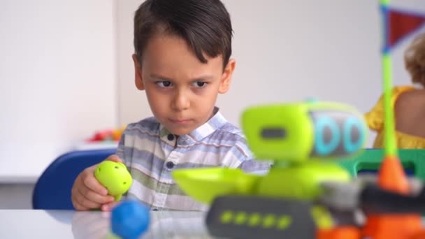 自動リモートカーのおもちゃとジョイスティックコントロールパネルを使用して テクノロジーを学ぶ幼稚園の少年 コーディング 子供のためのプログラミングベース — ストック動画