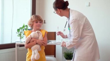 Çocuk aşısı çocuk hastanesi kliniğinde. Şırıngayla doktor enjeksiyonu. Çocuğun sağlıklı yaşam tarzı ve bakımı hakkında olumlu düşünceler.