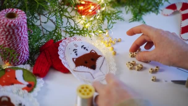 女性は自分の家のためのクリスマスデコレーションを作ります 熟練した技術と美しいおもちゃを生み出します 新しいイブの雰囲気 ファミリーの伝統 — ストック動画