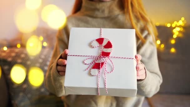 クリスマスパックのギフトボックスを与える居心地の良いセーターで閉じた若い女性 エキサイティングな若い大人のラッププレゼント新年のお祝いとおめでとう — ストック動画
