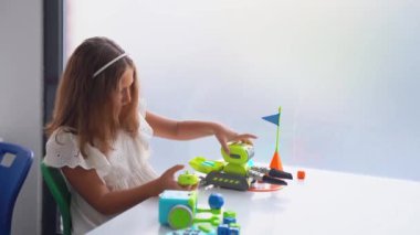 Okul öğrencisi teknoloji okuyor, uzaktan kumandalı otomatik araba oyuncağıyla kumanda paneli kullanıyor. Çocuklar için kodlama, programlama temelleri