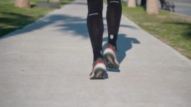 İzmir Türkiye 04.01.2023 Pist güneşli sabahında atlet bacaklarını kapatın. Koşucu maraton koşusuna, idman koşusuna şehir sabahında şehir merkezinde dayanıklılık egzersizine hazırlanıyor.