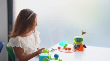 BTMM eğitim sınıfında oyuncak araba kontrol paneliyle oynayan bir çocuk. Okul öncesi çocukların ilk adımları teknolojiyi keşfetmek.