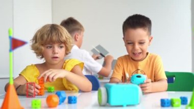 İlköğretim çağındaki çocuklar teknolojik eğitim kursunda elektronik oyuncak arabayla joystick oynuyorlar. Çocuk gelişimi, eğitim, iyi motor beceriler