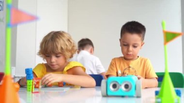 Okul öğrencileri teknoloji öğreniyor, uzaktan kumandalı otomatik araba oyuncağıyla kumanda paneli kullanıyorlar. Çocuklar için kodlama, programlama temelleri