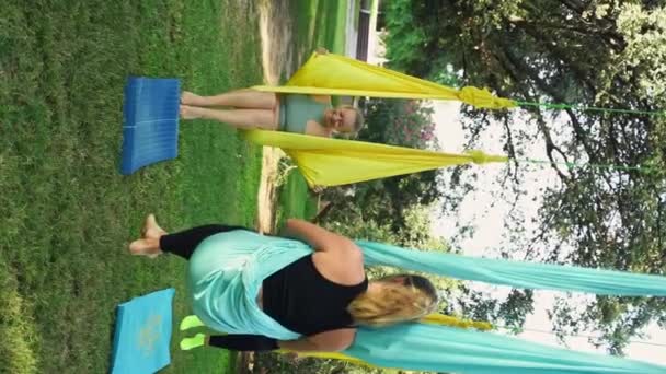 空中瑜伽由经验丰富的女教练指导 在安全和支助性的气氛中 为妇女举办的运动会上瑜伽课 教练训练舒适与安全每节课有效且愉快 — 图库视频影像