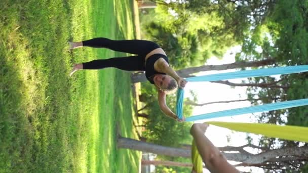 Istruttore Femminile Con Esperienza Conduce Sessione Aerea Yoga Nel Parco — Video Stock