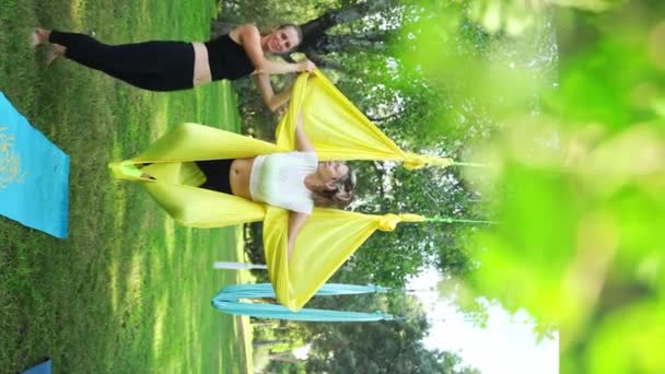 Aero Air Yoga Coach Instructor Explains Assist Women Participants Hammock — Stock Video